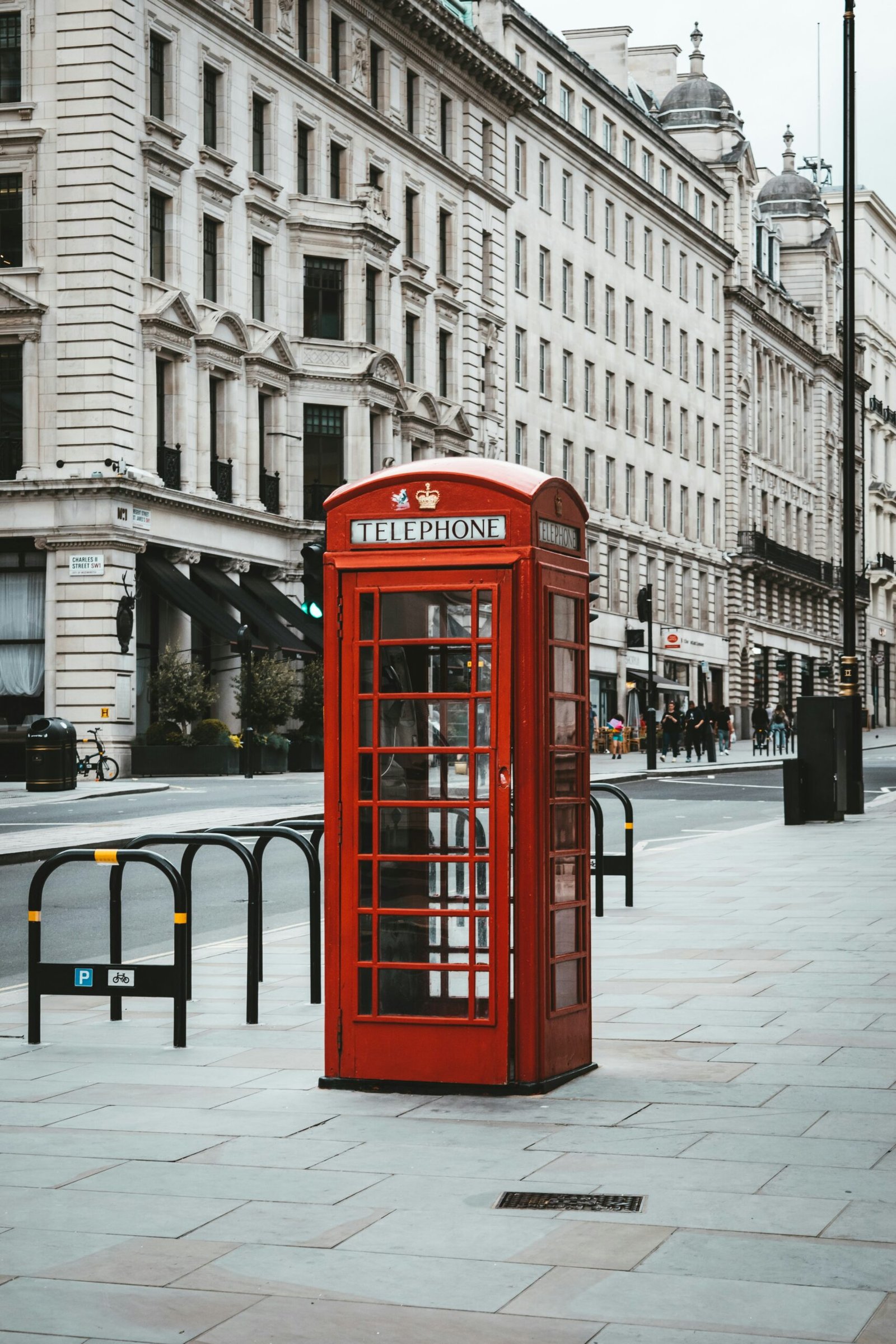 red telephone booth near white concrete building during daytime